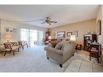 Comfortable living room featuring neutral colors, plush carpeting, and sliding doors to the outside at 10846 N Fairway E Ct, Sun City, AZ 85351