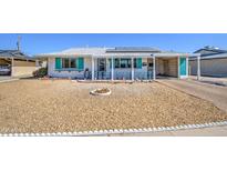 Charming home featuring a covered front porch, rock landscaping, and solar panels on the roof at 11407 N 111Th Ave, Sun City, AZ 85351