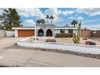 Charming single-story home with arched entryway, decorative front yard, and desert landscaping details at 13845 N 41St Ave, Phoenix, AZ 85053