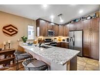 Modern kitchen features stainless steel appliances, custom cabinets, and a spacious island with seating at 24204 N 27Th Pl, Phoenix, AZ 85024