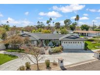 Stunning single-story home with a spacious driveway, 3-car garage, mature landscaping, and a cozy outdoor seating area at 5201 N 33Rd St, Phoenix, AZ 85018