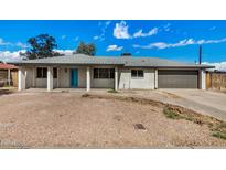 Charming single story home with a bright blue front door and a well maintained front yard at 5902 W Wolf St, Phoenix, AZ 85033