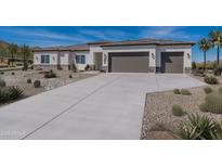 Stunning home featuring desert landscaping, neutral colors, and a wide driveway leading to a two-car garage at 9278 E Cloudview Ave, Gold Canyon, AZ 85118