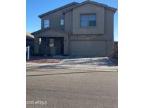 Two-story home featuring a covered porch, an attached two-car garage, and a combination of stucco and siding at 11821 W Yuma St, Avondale, AZ 85323