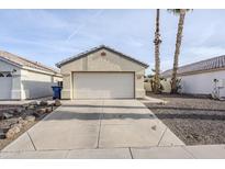 Attached two-car garage featuring neutral paint, a well-maintained driveway and desert landscaping at 1780 E Countrywalk Ln, Chandler, AZ 85225