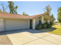 This lovely home features an attached two-car garage and a charming covered front porch at 4843 E Ajo Cir, Phoenix, AZ 85044