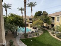 Community pool featuring palm trees, chaise lounges, grass and lush landscaping in a desert climate at 7887 N 16Th St # 227, Phoenix, AZ 85020