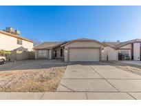 Charming single-story home featuring a low-maintenance desert landscape and attached two-car garage at 8709 W Roanoke Ave, Phoenix, AZ 85037