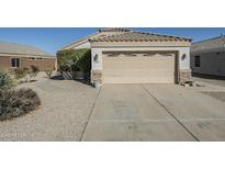 Attached garage with concrete driveway and desert landscaping in front yard at 1186 E Bradstock Way, San Tan Valley, AZ 85140