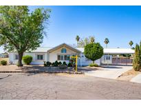 Charming single-story home featuring a covered carport, mature landscaping, and a welcoming facade at 15618 N 68Th Dr, Peoria, AZ 85382