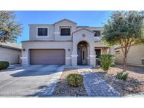 Inviting two-story home with a well-maintained front yard, arched entryway, and a two-car garage at 20867 N Grantham Rd, Maricopa, AZ 85138