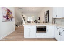 Open-concept kitchen with white cabinets, stainless steel appliances, and an island with a built-in microwave at 4438 N 27Th St # 24, Phoenix, AZ 85016