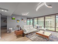Bright living room features modern lighting, neutral tones, and large windows for natural light and city views at 4808 N 24Th St # 906, Phoenix, AZ 85016