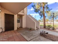 Welcoming front entrance with secure gate, stairs to an upper-level unit, and a landscaped walkway at 7800 E Lincoln Dr # 1100, Scottsdale, AZ 85250