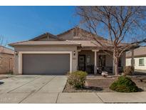 Charming single-story home featuring a two-car garage, covered porch, and low maintenance desert landscaping at 8734 S 57Th Dr, Laveen, AZ 85339