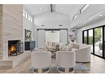 Bright living room features vaulted ceilings, modern fireplace, stylish furniture and sliding barn doors at 10435 N 98Th St, Scottsdale, AZ 85258