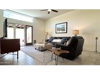 Bright living room boasts a large window, sliding glass door, tile flooring and comfortable furniture at 11772 E Clinton St, Scottsdale, AZ 85259