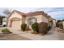 Charming single-story home with a two-car garage and mature landscaping at 14130 W Bent Tree Cir, Litchfield Park, AZ 85340