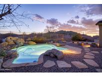 Backyard pool with rock features, desert landscaping, and picturesque mountain views at 18391 W Verdin Rd, Goodyear, AZ 85338