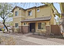 Two story tan home with stone veneer accents and a covered front entryway at 2568 E Boston St, Gilbert, AZ 85295