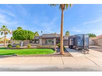 Charming single-story home featuring a well-manicured lawn, mature trees, and a private driveway with trailer at 4037 S Taylor Dr, Tempe, AZ 85282