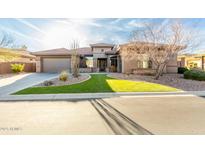 Stunning desert home featuring a three car garage, stone accents, manicured front yard, and a well-lit entry at 40930 N Lambert Trl, Phoenix, AZ 85086
