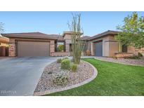 Attractive single-story home with a three-car garage, desert landscaping, and lush green grass at 40930 N Lambert Trl, Phoenix, AZ 85086