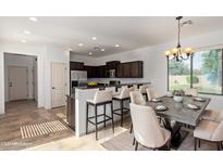 Eat-in kitchen with a dining area featuring a stylish chandelier and a dark wood kitchen with breakfast bar at 4428 E Wildhorse Dr, Gilbert, AZ 85297
