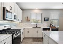Modern kitchen featuring white cabinets, subway tile backsplash, stainless steel appliances, and quartz countertops at 5140 E Desert Forest Trl, Cave Creek, AZ 85331