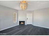 Cozy living room featuring a fireplace, modern light fixture, and sleek gray flooring at 9451 E Becker Ln # 2027, Scottsdale, AZ 85260