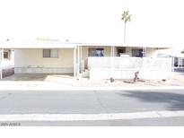 Exterior view of a mobile home with a covered parking area and small front yard at 9501 E Broadway Rd # 237, Mesa, AZ 85208