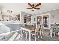 Inviting dining area with a wooden table, gray flooring, and a stylish ceiling fan at 10533 W Granada Dr, Sun City, AZ 85373