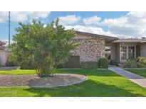 Charming home with a well-maintained lawn and mature landscaping featuring a brick facade at 10533 W Granada Dr, Sun City, AZ 85373