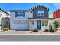 Charming two-story home featuring a blue front door, two car garage, and landscaped yard at 1901 W 23Rd Ave, Apache Junction, AZ 85120