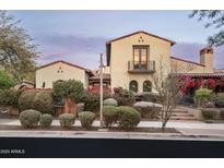 Charming stucco home with a balcony, clay tile roof, lush landscaping and beautiful bougainvillea at 20299 N 102Nd Pl, Scottsdale, AZ 85255