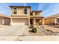 Charming two-story home featuring a tile roof, arched windows, and a two-car garage with a desert landscape at 21397 N Goles Dr, Maricopa, AZ 85138