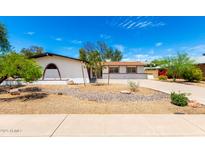 Charming home exterior with white stucco, brown trim, desert landscaping and a winding driveway at 2142 E Palmcroft Dr, Tempe, AZ 85282