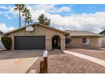 Charming brick home featuring a spacious garage, front yard, and an arched doorway, with a mailbox near the driveway at 2671 W Bentrup St, Chandler, AZ 85224