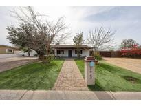 Charming single-story home featuring a walkway, green lawn, and well-maintained landscaping at 2923 E Wahalla Ln, Phoenix, AZ 85050