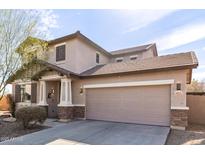 Charming two-story home showcasing a two-car garage and well-kept landscaping at 4019 W Valley View Dr, Laveen, AZ 85339