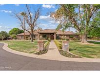 Stately brick home featuring mature trees, lush lawn, and charming pathway leading to the grand entrance at 4222 E Brown Rd # 18, Mesa, AZ 85205