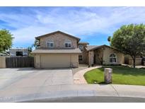 Charming two-story home featuring a lush lawn, stone accents, and a spacious driveway at 609 W Mcnair St, Chandler, AZ 85225