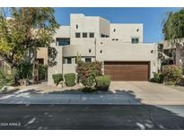 Contemporary home with desert landscaping, tan stucco, brown garage door, and well maintained yard at 6711 E Camelback Rd # 43, Scottsdale, AZ 85251