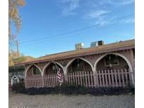 Charming single-story home featuring an arched porch with a quaint picket fence and an American flag at 885 E Commonwealth Pl, Chandler, AZ 85225