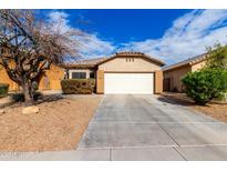 Charming one-story home with a low maintenance front yard and white garage door at 8850 W Laurel Ln, Peoria, AZ 85345