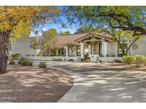 Stunning single-story home featuring a spacious front yard with a circular driveway and covered porch area at 9901 N 51St Pl, Paradise Valley, AZ 85253