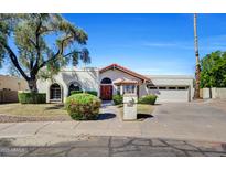 Charming home featuring mature tree, arched windows and tiled roof, offering timeless curb appeal at 10540 N 78Th Pl, Scottsdale, AZ 85258