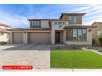 Two-story home features a well manicured front yard, three-car garage, and neutral color palette at 11679 W Parkway Ln, Avondale, AZ 85323