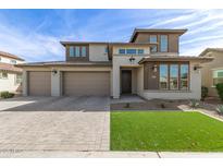 Charming two-story home with a three car garage, manicured landscaping and brick paved driveway at 11679 W Parkway Ln, Avondale, AZ 85323