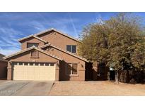 Charming two-story home featuring a tan stucco exterior, a two-car garage, and desert landscaping at 2016 S 66Th Ln, Phoenix, AZ 85043